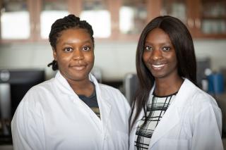 两个穿着实验服的女学生在科学实验室里