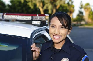 一名身穿制服的女警察站在警车旁